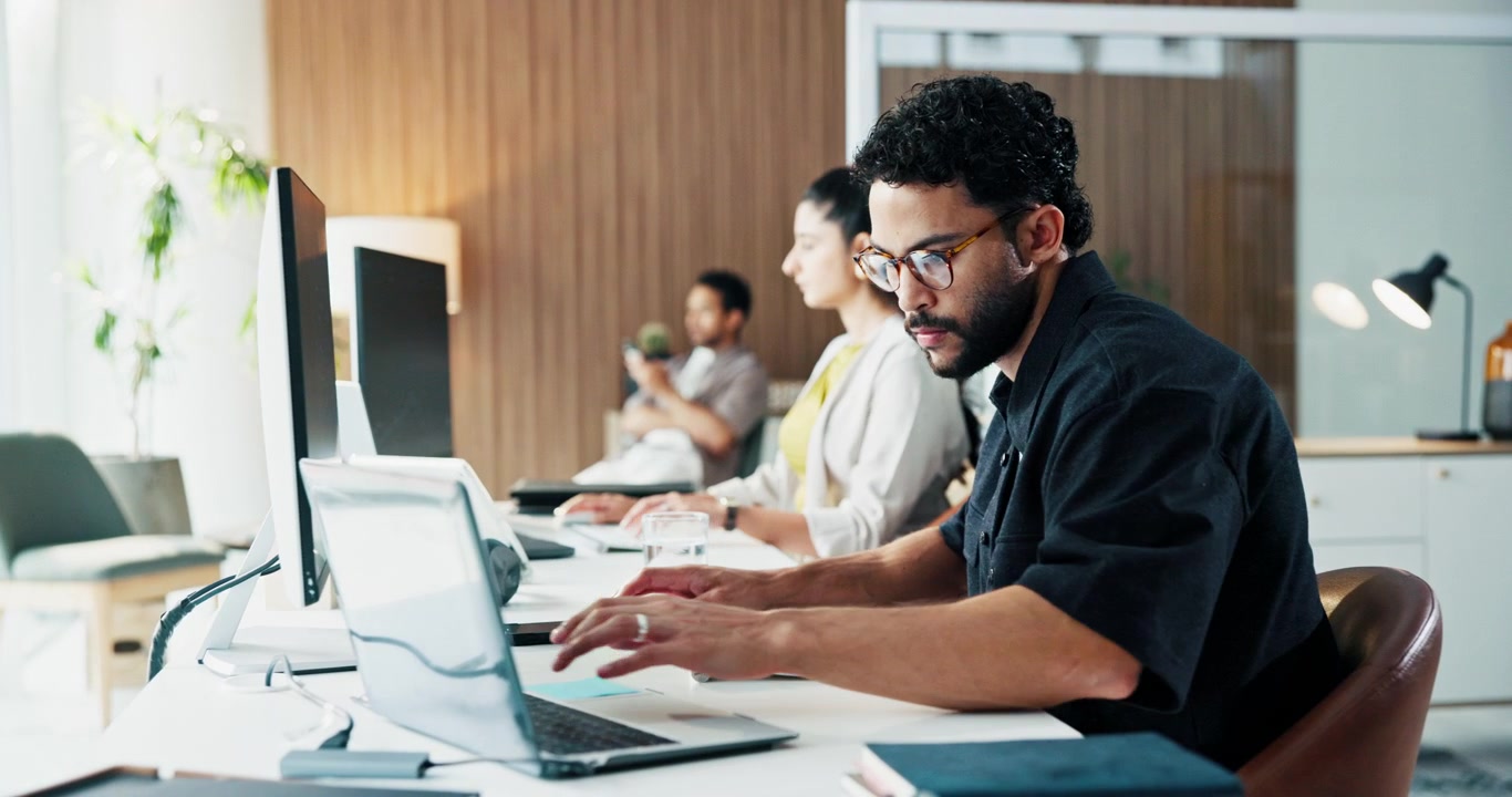 Focused Professional Man Working on Laptop in Modern Office