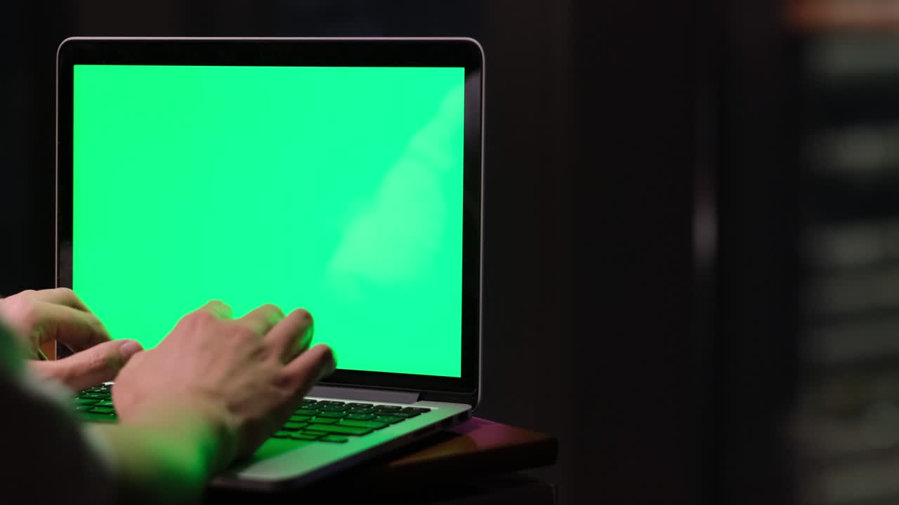 escritura a mano en una computadora portátil de pantalla verde por la noche