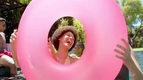 retrato de amigos felices y diversos jugando con inflables en la fiesta de la piscina en verano