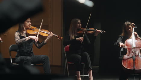 rehearsal of small orchestra in philharmonic hall cellist and violinists are playing music