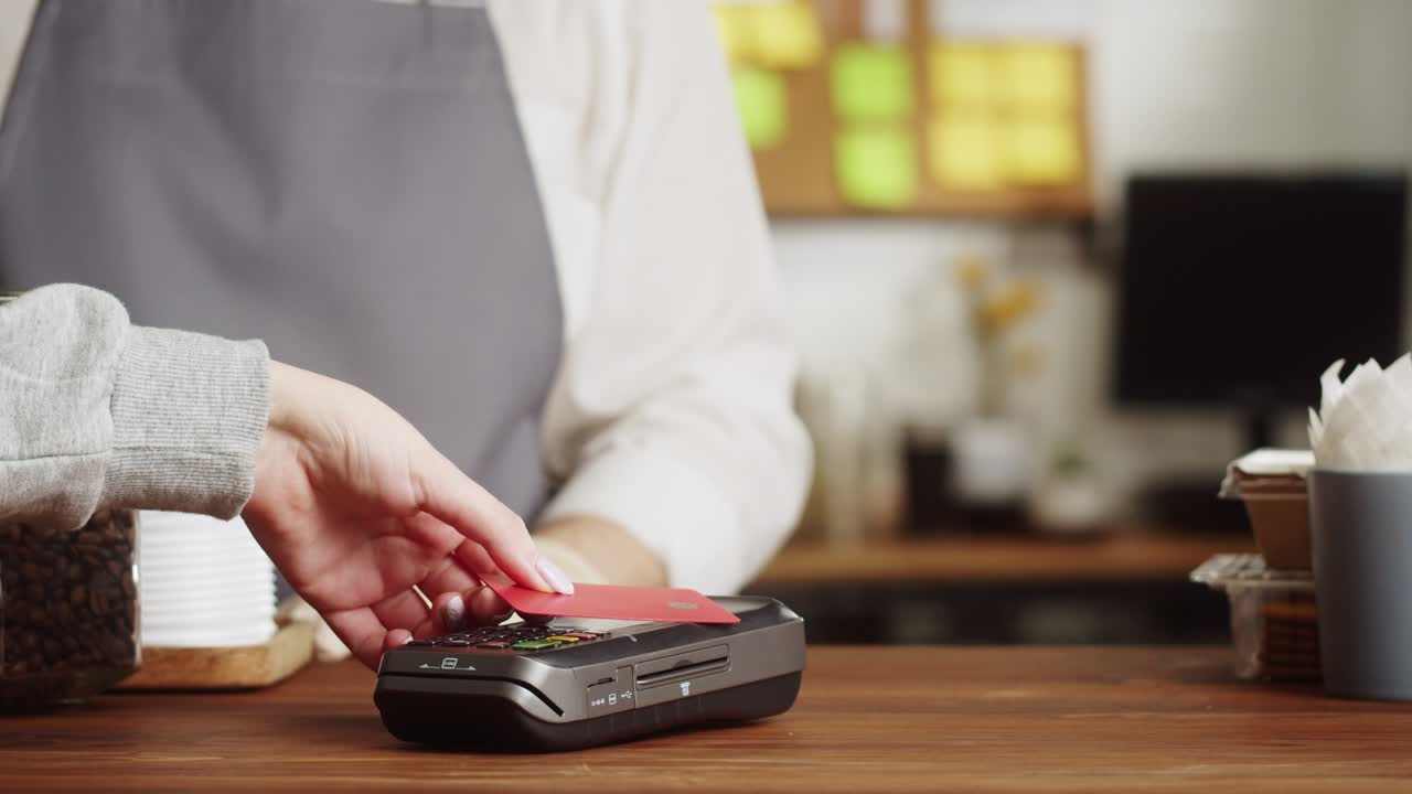 Paying with credit bank card in cafe. Buying coffee, take away hot drink. Touch-free and contactless food shopping. NFC technology concept.
