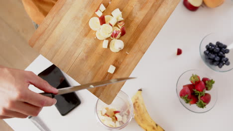 Hände-Eines-Biracial-Mannes,-Der-In-Der-Küche-Smoothie-Mit-Gehacktem-Obst-Zubereitet,-Kopierraum,-Zeitlupe