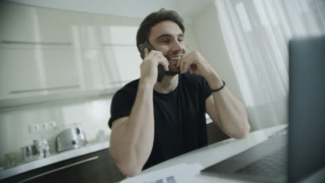 hombre sonriente hablando por teléfono móvil en el lugar de trabajo de casa. hombre de negocios feliz llamada telefónica