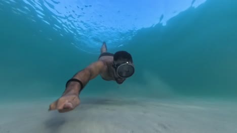 freediving going down to the sand plain