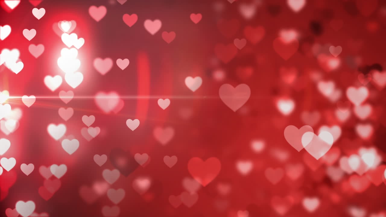 animación de corazones rojos brillantes cayendo sobre un fondo oscuro.