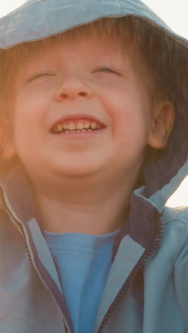 kid finds joy in downpour against sunshine. happy boy plays in refreshing rainfall with innocence shining bright among gray sky. pure happiness