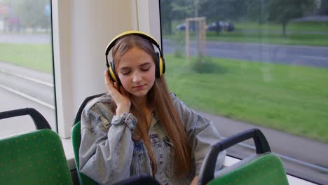 Young-woman-wearing-headphones-listening-music,-funny-relax-dancing-while-traveling-by-bus-to-city