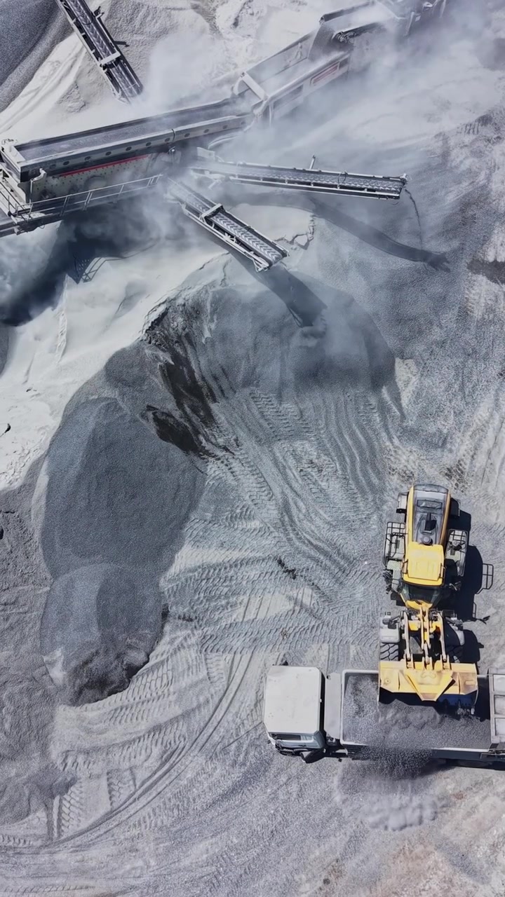 Heavy machinery working in gravel pit during day