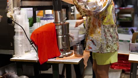 person making juice at a market stall