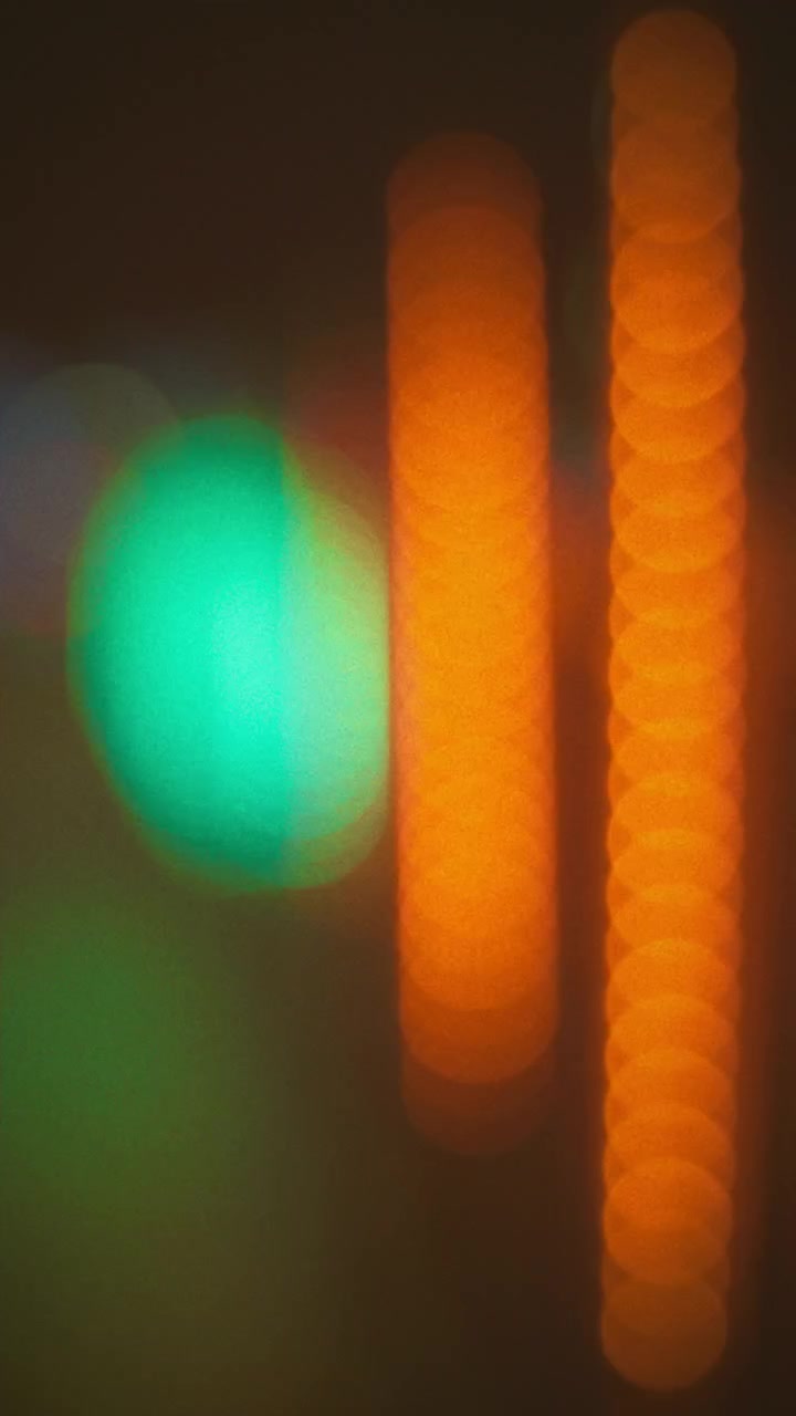 Abstraktní bokeh světla blikající zeleně a oranžově