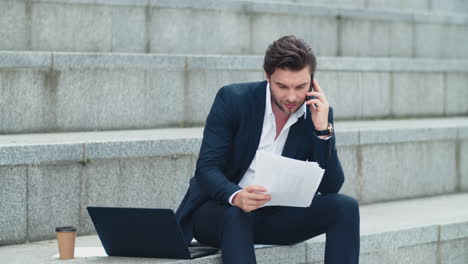 hombre de negocios hablando por teléfono inteligente con un cliente. ejecutivo leyendo periódicos de negocios