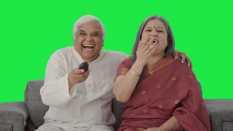 Happy-Old-Indian-couple-watching-TV-and-laughing-Green-screen