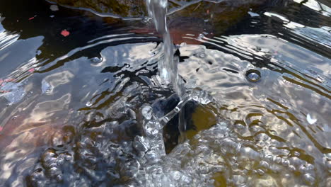 slow motion shot of splashing water of fishpond pump for fresh oxygenated water for fishes life