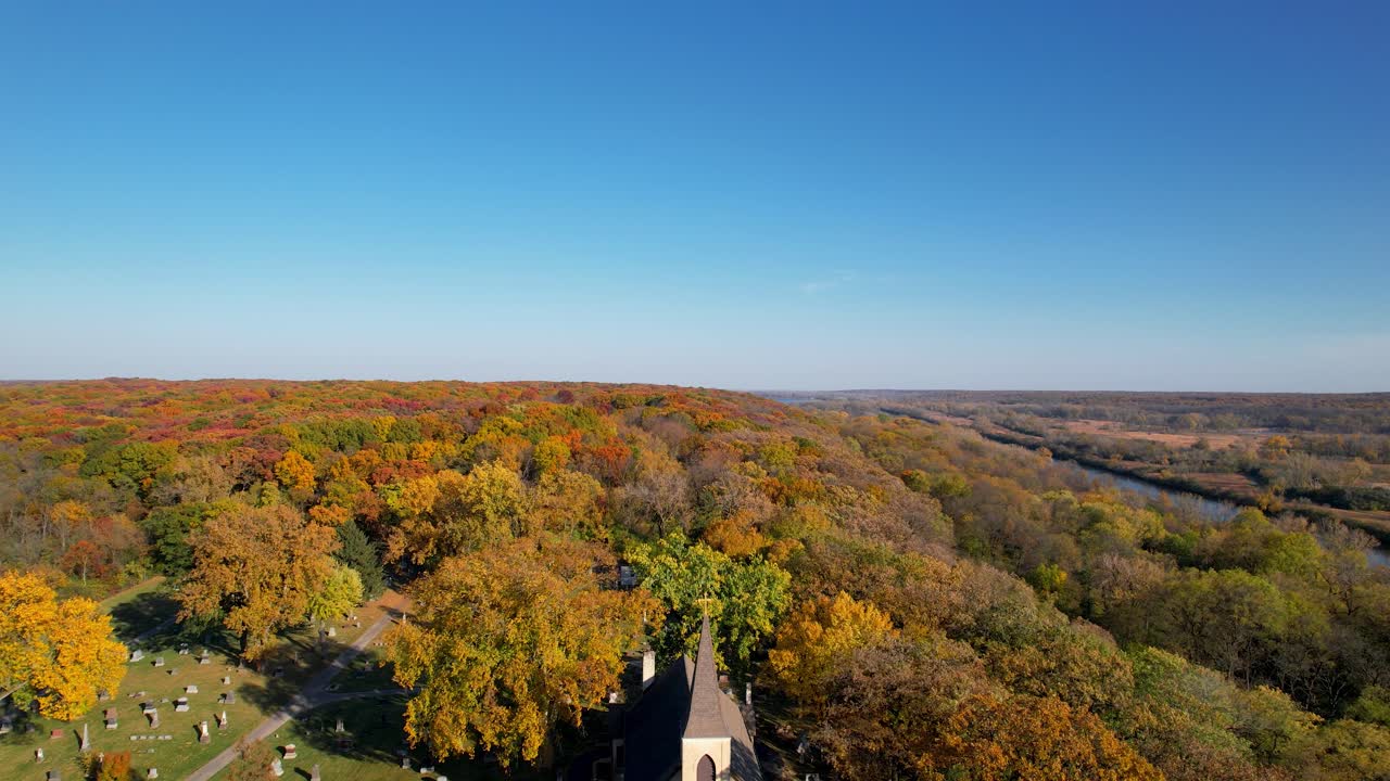antigua iglesia católica rural con colorido bosque otoñal y cielo azul drone
