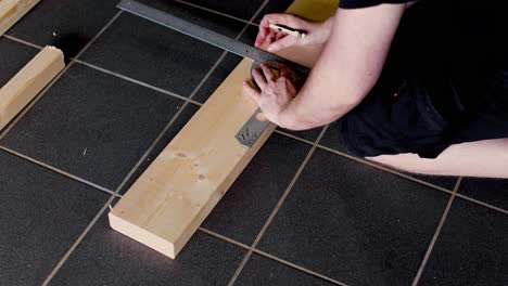 marking a cut line with a straight edge and control measuring with a tape measure before cutting in 4k.