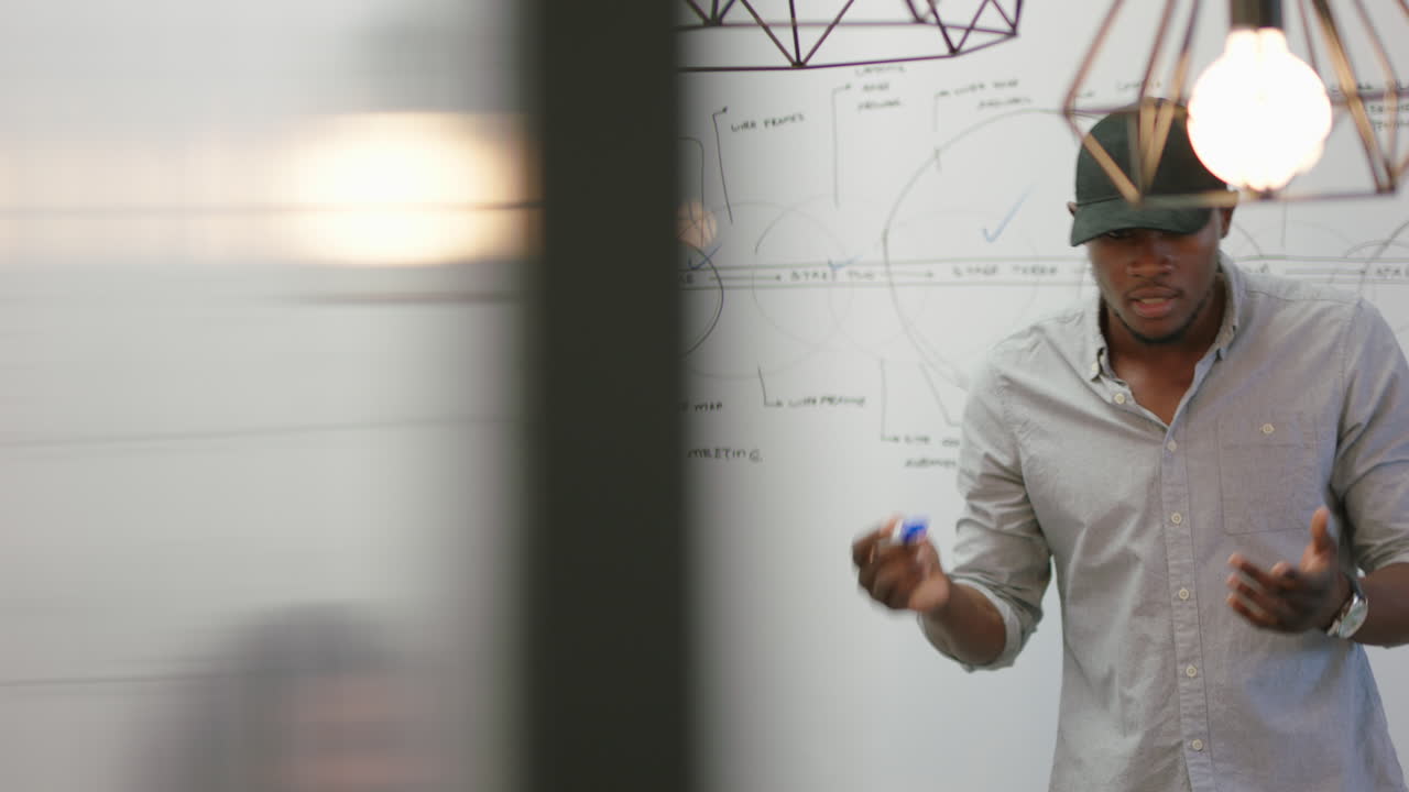 empresarios afroamericanos se reúnen en la sala de juntas líder del equipo creativo empresario presenta una conferencia corporativa muestra a sus colegas información sobre la pizarra capacitación de estudiantes en la oficina de inicio