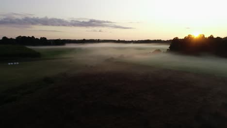 Flight-above-sunset-fog-in-golden-hour-after-rain