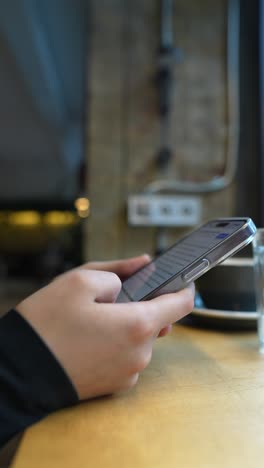 person using smartphone in a cafe