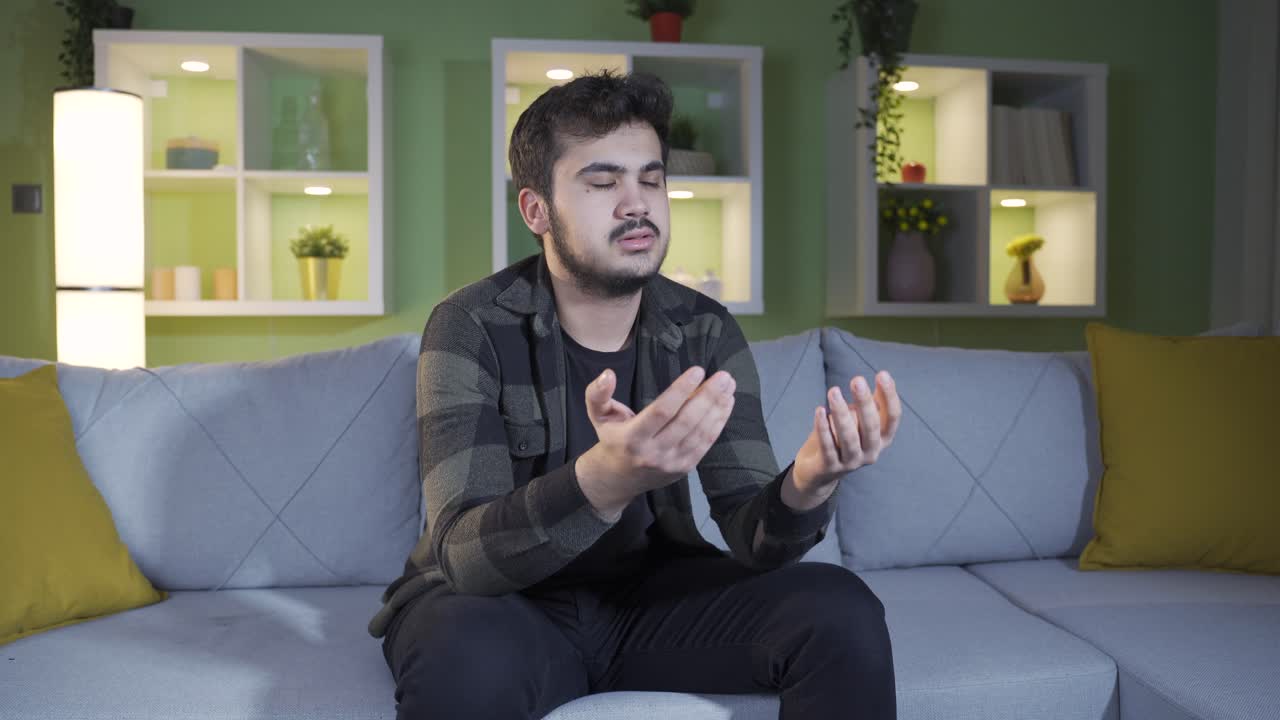 Muslim young man praying at home. Islamic religion.
