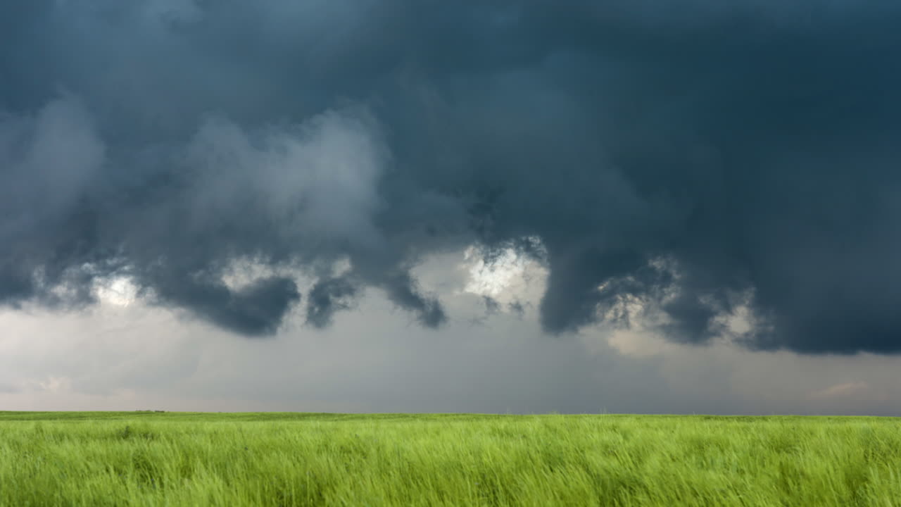 Spinning Storm Clouds Over Fields Of Green Grass In Spring