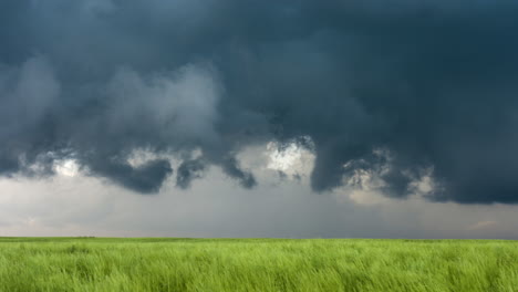 spinning storm clouds over fields of green grass in spring