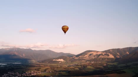 Gelber-Heißluftballon,-Der-Bei-Sonnenaufgang-über-Die-Landschaft-Gleitet---Hochwinkelansicht