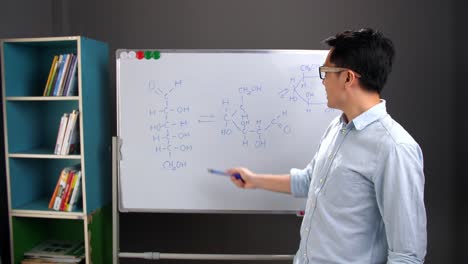 asian male chemist teacher explain scientific