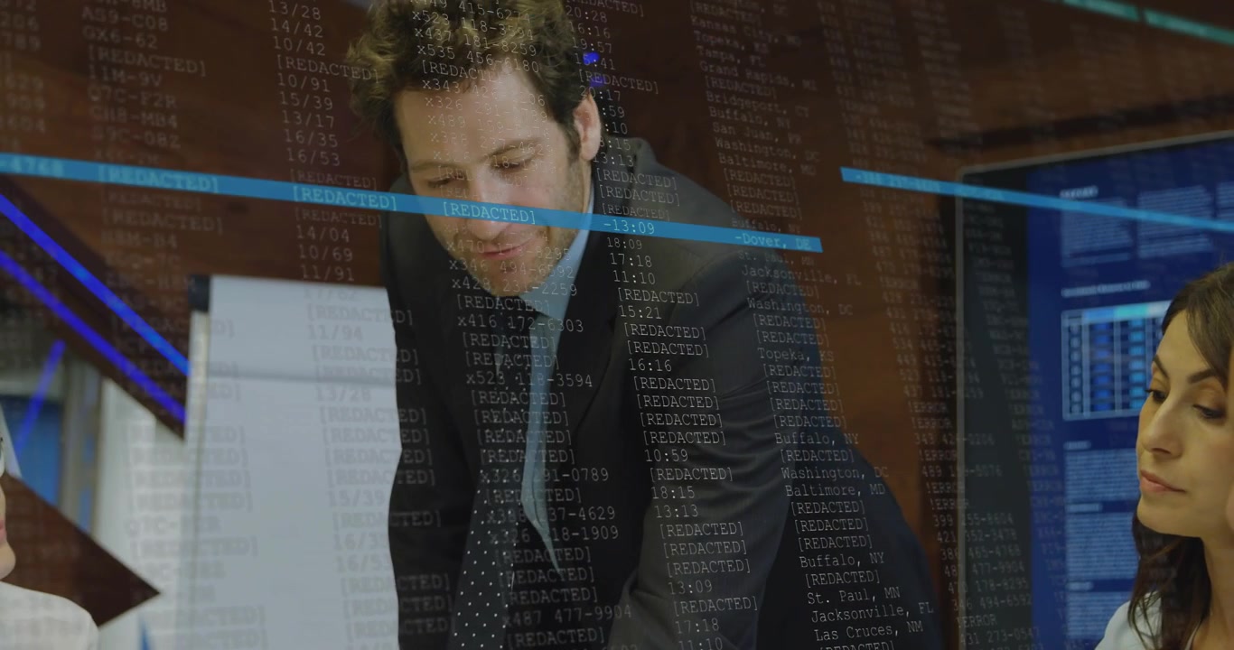 Man entering room and leading discussion on business data with scrolling code overlay on monitors
