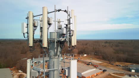 aerial shot revolving around cell phone tower in forest. close up