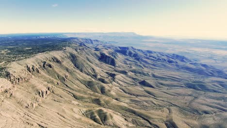 Lincoln-National-forest-cliff-view,-aerial-wide-shot-of-hazy-day-in-the-mountains,-rocky-sedimentary-highlands,-large-cliff-valley-in-New-Mexico
