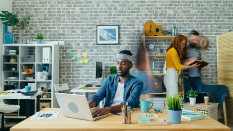 busy office scene with man working on laptop