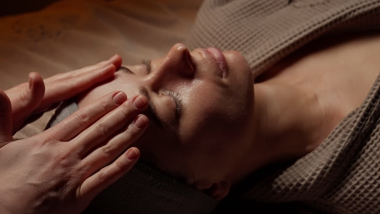 Kvinde får afslappende ansigtsmassage i en spa