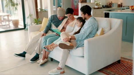 Grandparents,-dad-and-child-on-sofa-with-book