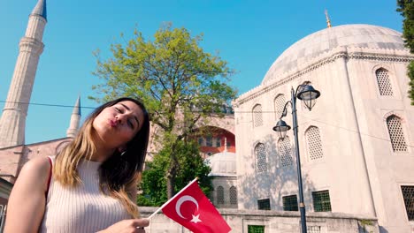 Zeitlupe:-Schöne-Junge-Mädchen-Winken-Türkische-Flagge-Vor-Einem-Alten-Gebäude-In-İstanbul,-Türkei,-Reisekonzept