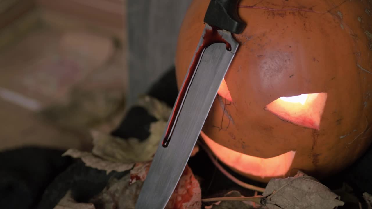 espeluznante calabaza tallada de halloween con un cuchillo goteando sangre