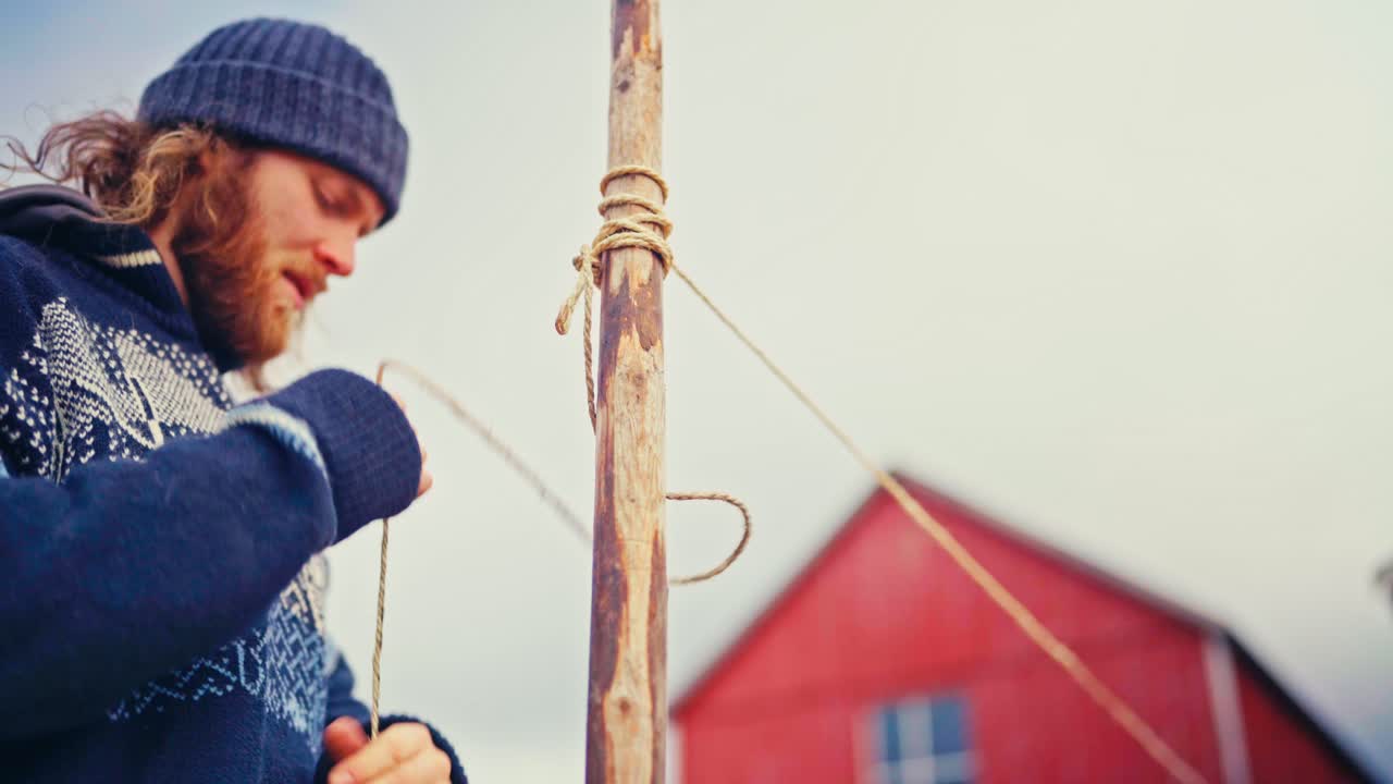 Charred Stakes are Being Set Into the Ground by a Man to Mark the Field's Boundaries - Close Up