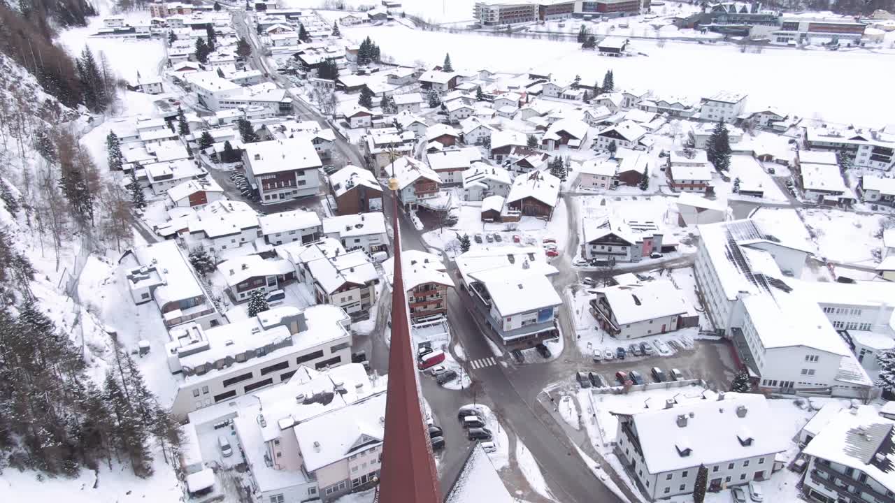 Aerial view of Austrian village covered in snow, drone shot of Oberlängenfeld at winter.  Oberlängenfeld covered in snow.