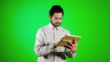 guy-using-mobile---tablet-with-green-screen-and-green-background-indian-guy-with-green-screen