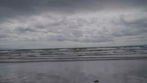 on a very overcast day with grey clouds sea water flows in slow motion