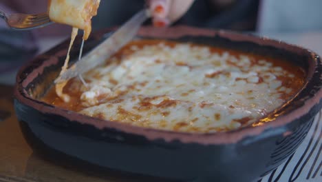 person eating lasagna