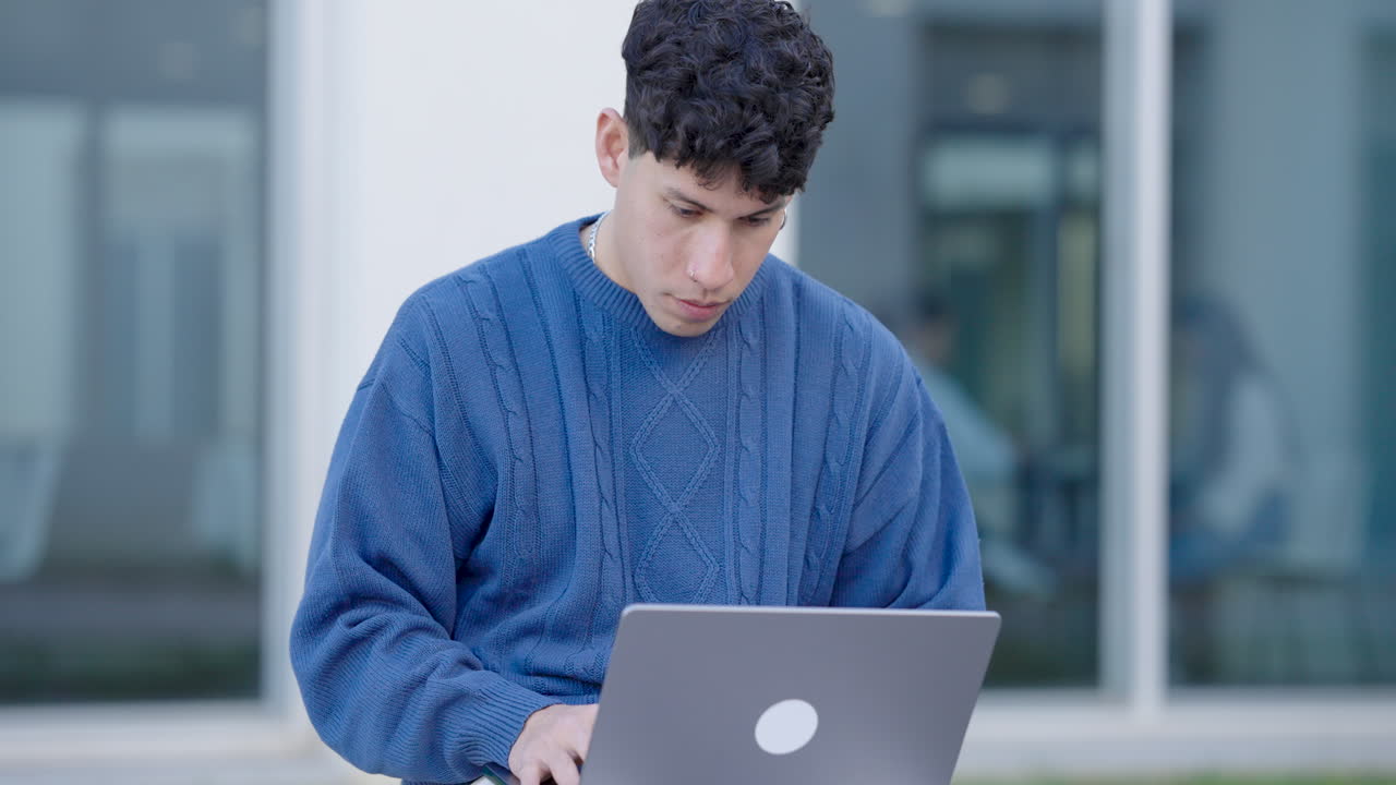 Young hispanic student working on laptop computer