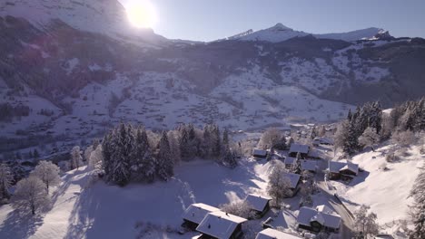 雪覆蓋的小屋和杉樹 揭示了格林德爾瓦爾德村的部分