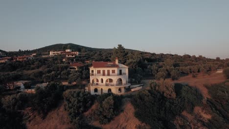 Trikorfo-Beach-in-Greece-aerial-Scene-with-sea-cottages-and-green-upland