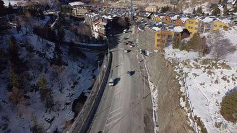 Aerial-view-of-vehicles-on-mountain-road-arriving-to-urban-nucleus