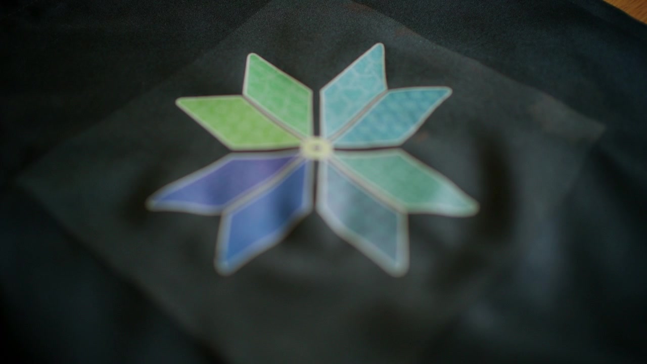 Detailed close up of a colorful floral heat transfer design successfully applied to black fabric