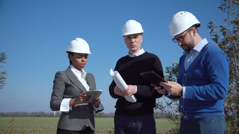 engineering team discussing plans at wind farm