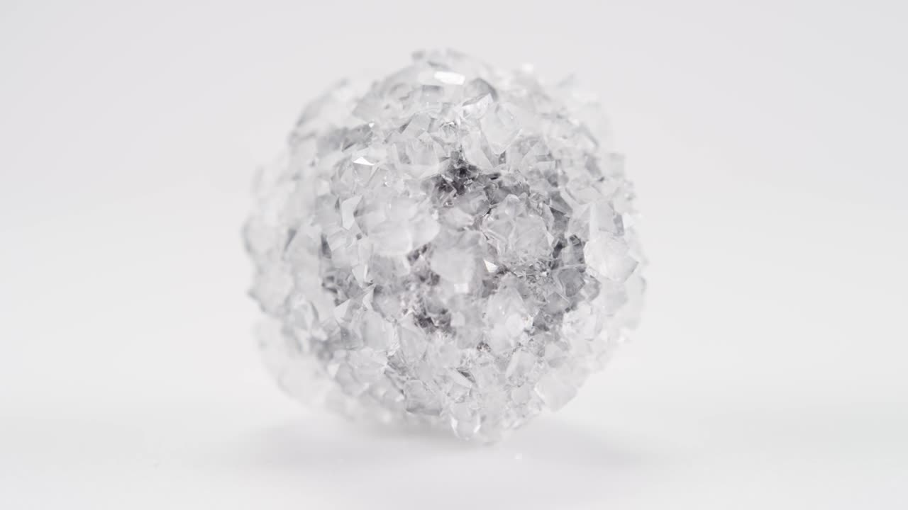 어두운 중심을 가진 보락스 결정은 밝은 배경에 대해 무한 루프로 회전합니다.