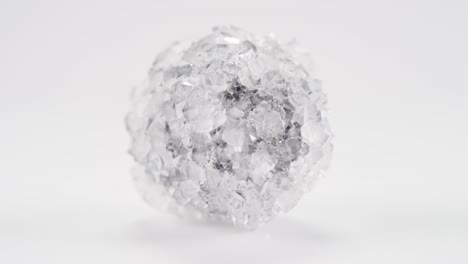 cristal de bórax con centro oscuro gira en bucle infinito contra un fondo claro