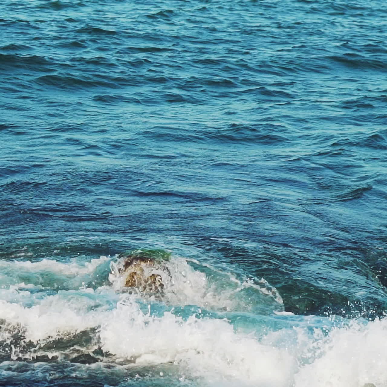 Sea. Splashes of the wave scatter from the impact of the breakwater. Slow motion.