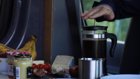 making coffee in the morning with french press - vanlife breakfast - close up